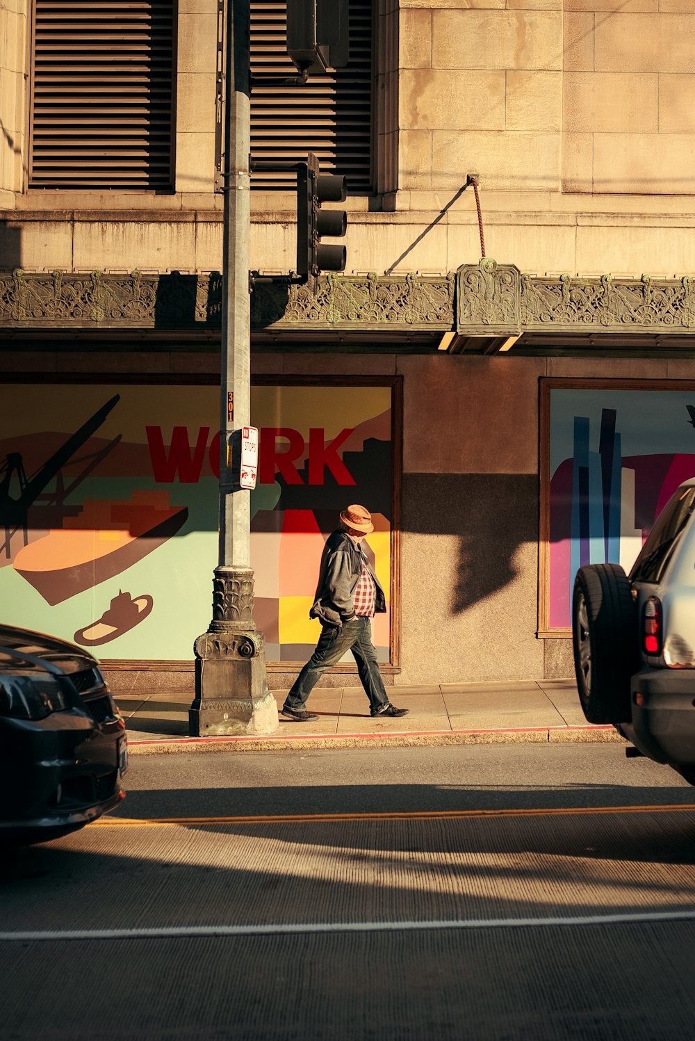 a man walking down a street next to a tall building