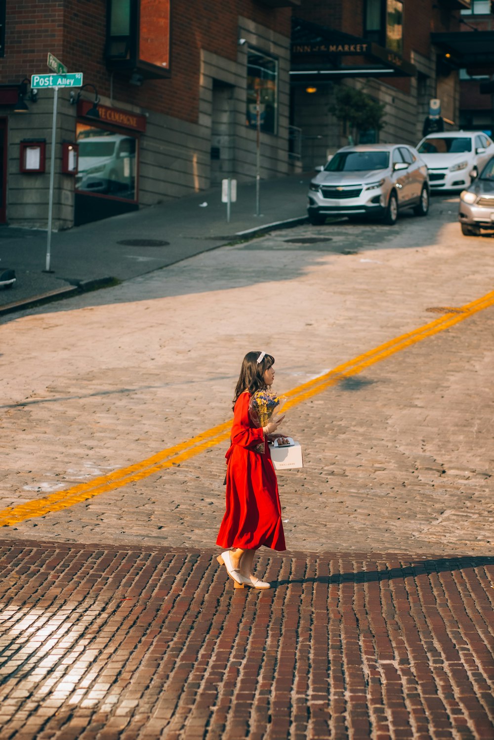 a woman in a red dress walking down a street