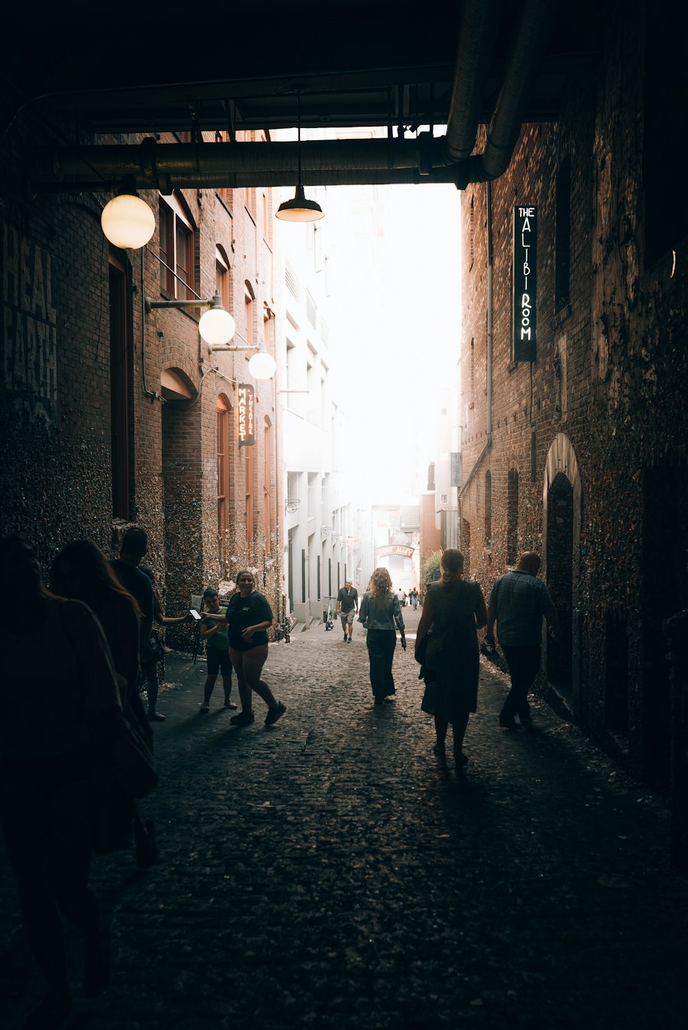 a group of people walking down a street next to tall buildings