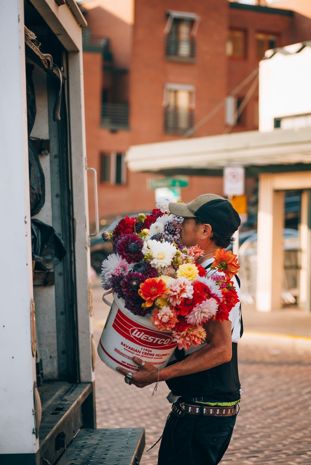a man is holding a large bucket of flowers