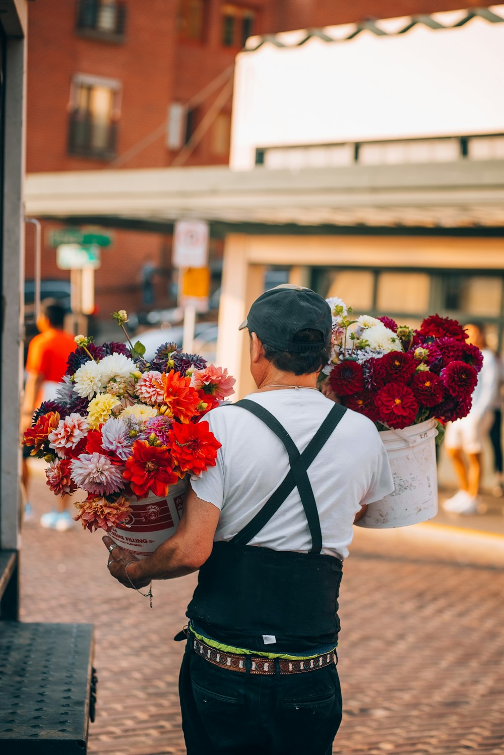 a man carrying a bunch of flowers down a street