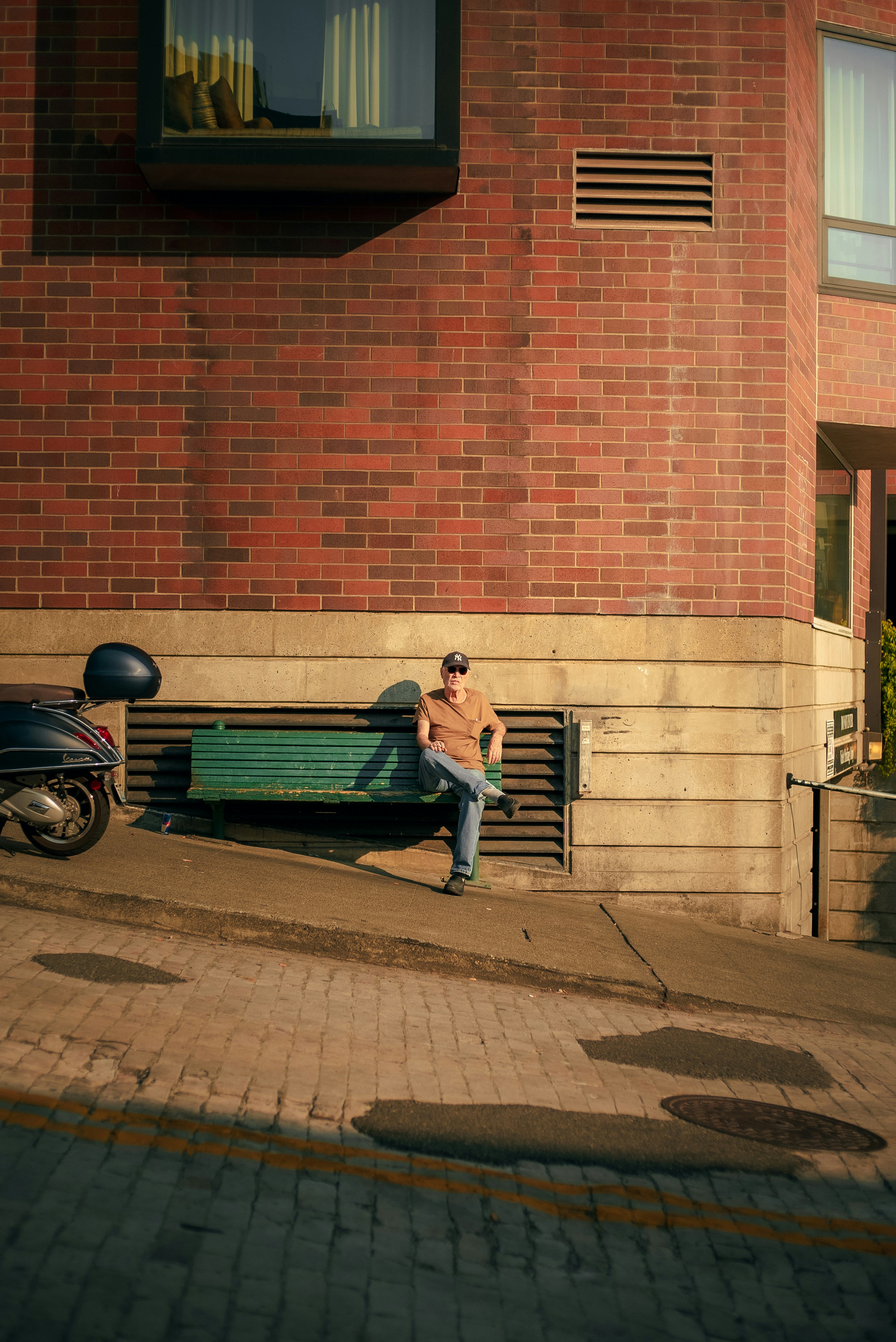 A man sitting on a bench in front of a building photo – Free Seattle ...