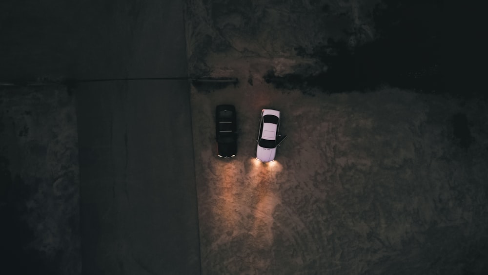 two cars parked in a parking lot at night