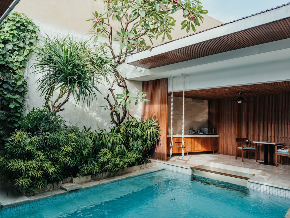 una piscina con una mesa y sillas al lado