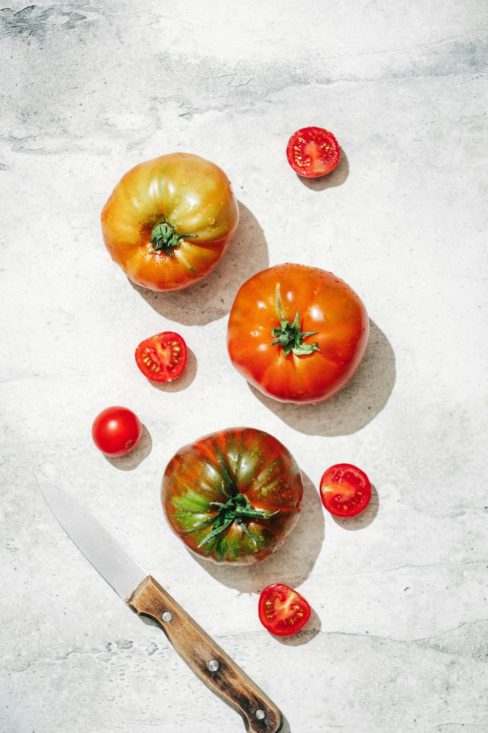 a knife and some tomatoes on a table