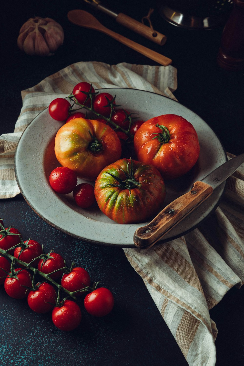 a plate of tomatoes and a knife on a table