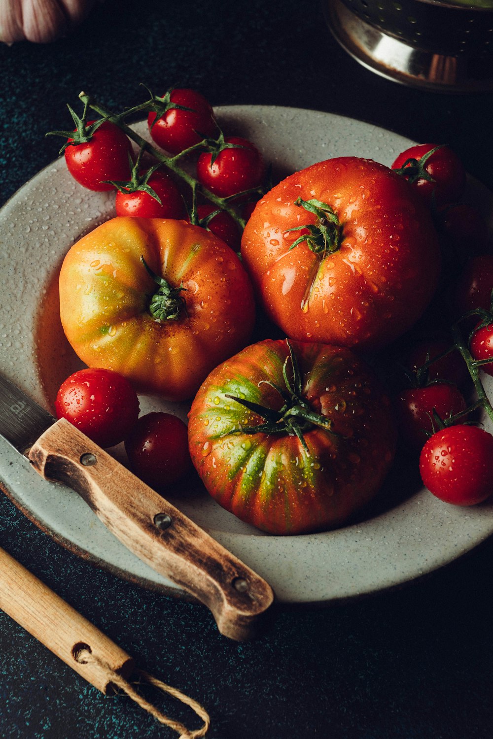 a white plate topped with tomatoes and a knife