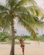 A professional model posing on a tropical beach in Costa Rica during a photoshoot.