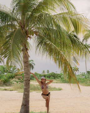 A professional model posing on a tropical beach in Costa Rica during a photoshoot.