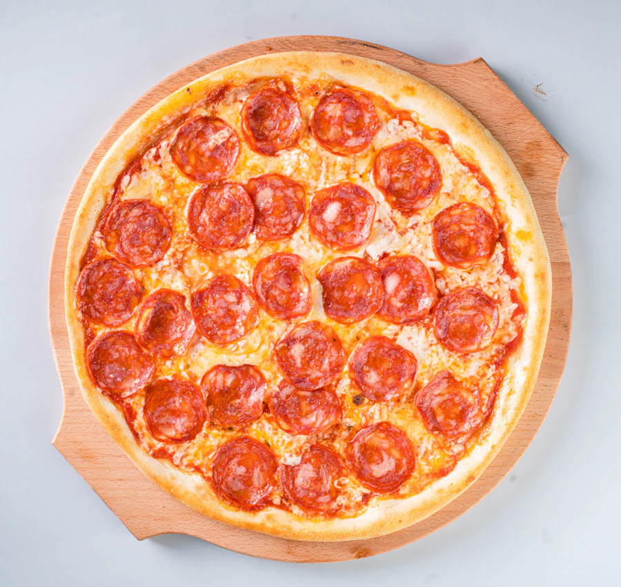 Pepperoni pizza, hand-pulled, served on a wooden board