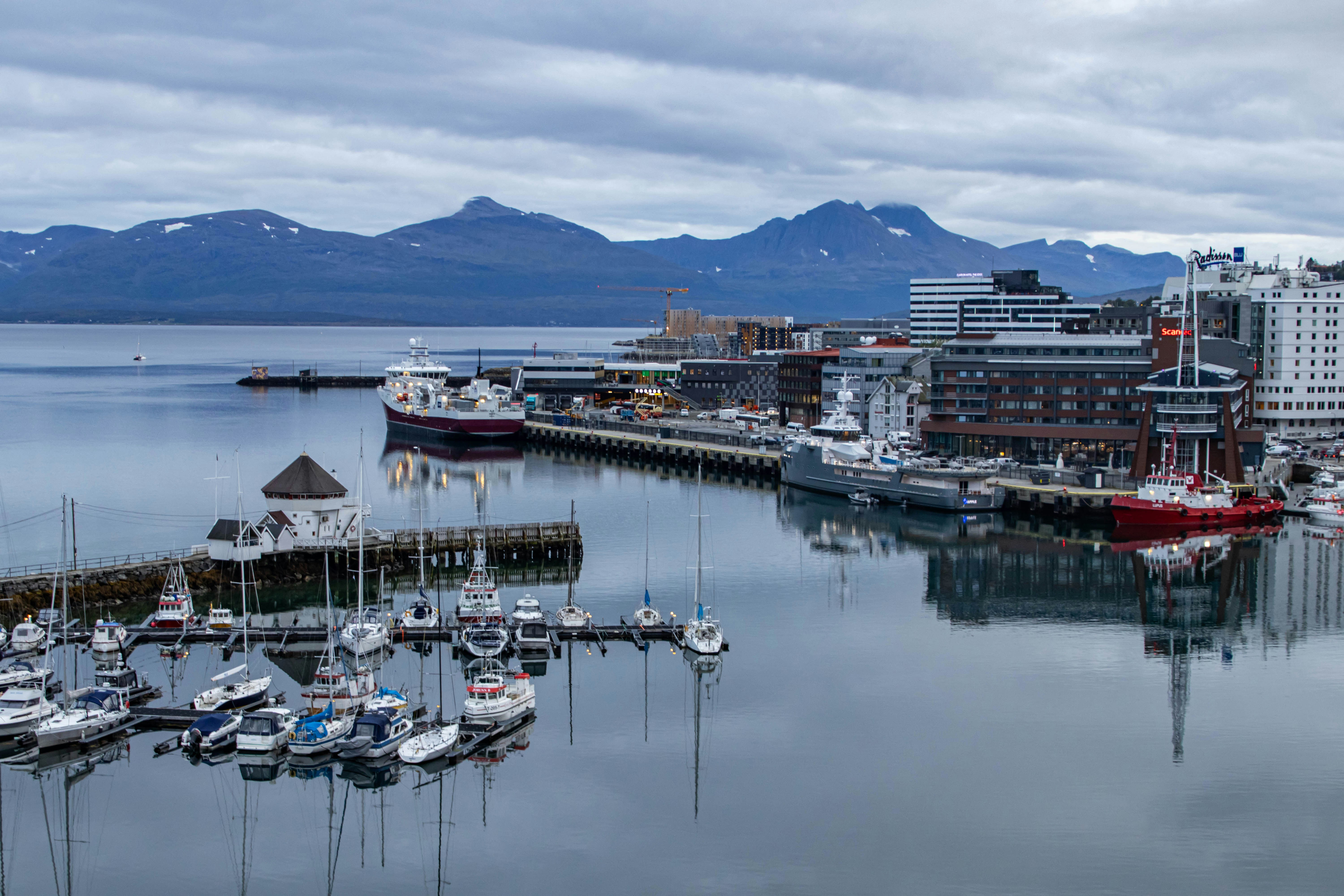 a harbor filled with lots of boats next to tall buildings