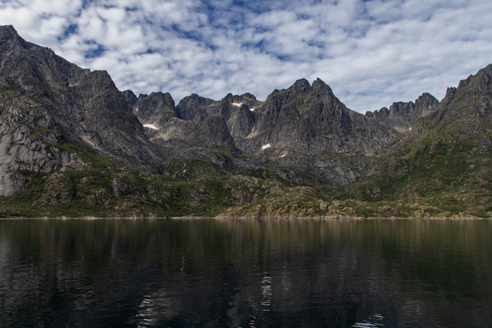 the mountains are reflected in the still water of the lake