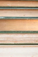 Stack of handcrafted books with textured covers in muted earth tones.