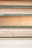 Several stacked books showing their aged and textured spines and pages, varying in color from shades of cream to light brown. Each book is bound with a greenish cover, hinting at their vintage nature.