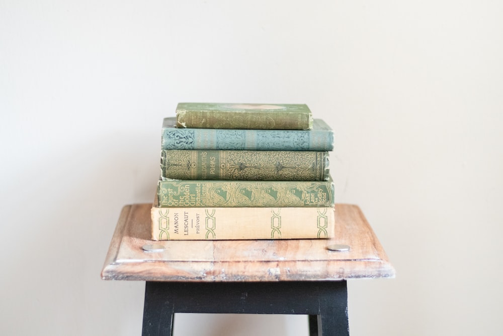 a stack of books sitting on top of a wooden table