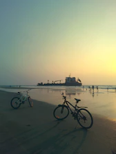 Scenic view of rental bikes lined up near the beach road in Puri at sunset.
