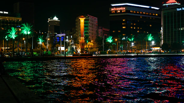 A vibrant Miami beach scene at sunset with lively crowds and colorful lights reflecting the city's energetic entertainment vibe.