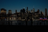 Silhouetted executives in a high-rise boardroom with a city skyline at dusk.