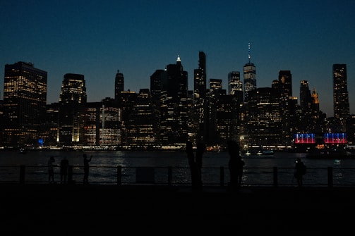 Silhouetted executives in a high-rise boardroom with a city skyline at dusk.