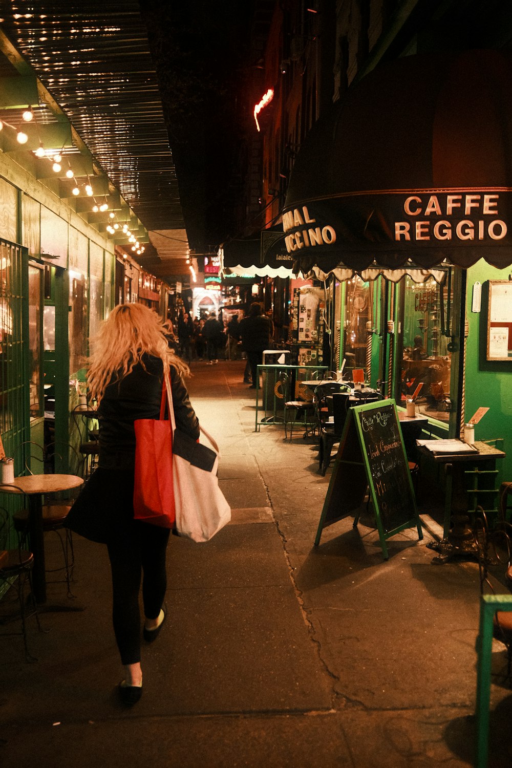 a woman walking down a street at night