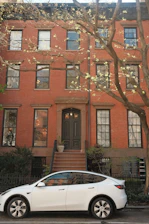 Electric car parked outside a stylish rental property with a welcoming entrance.