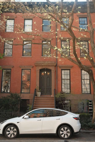Electric car parked outside a stylish rental property with a welcoming entrance.
