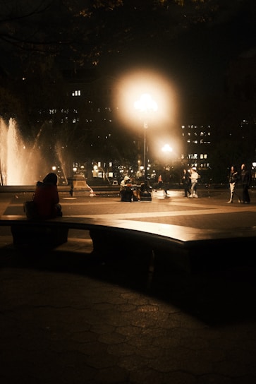 A serene public square with a modern water fountain gently flowing under soft evening lights.