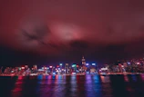 An atmospheric photo of a nighttime city skyline with neon reflections, evoking the nocturnal vibe.
