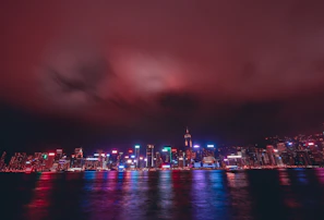 An atmospheric photo of a nighttime city skyline with neon reflections, evoking the nocturnal vibe.