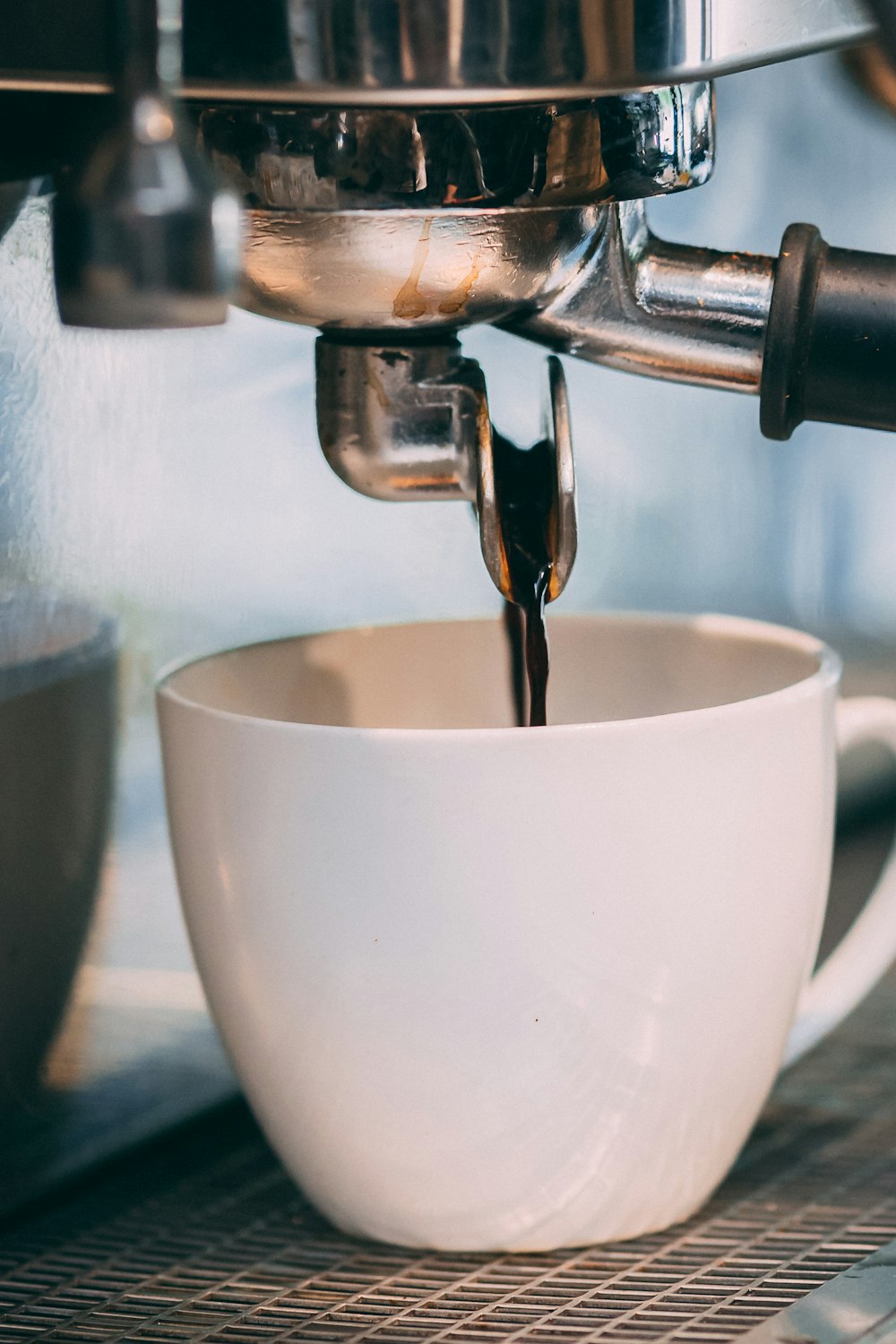 a coffee maker pouring a cup of coffee