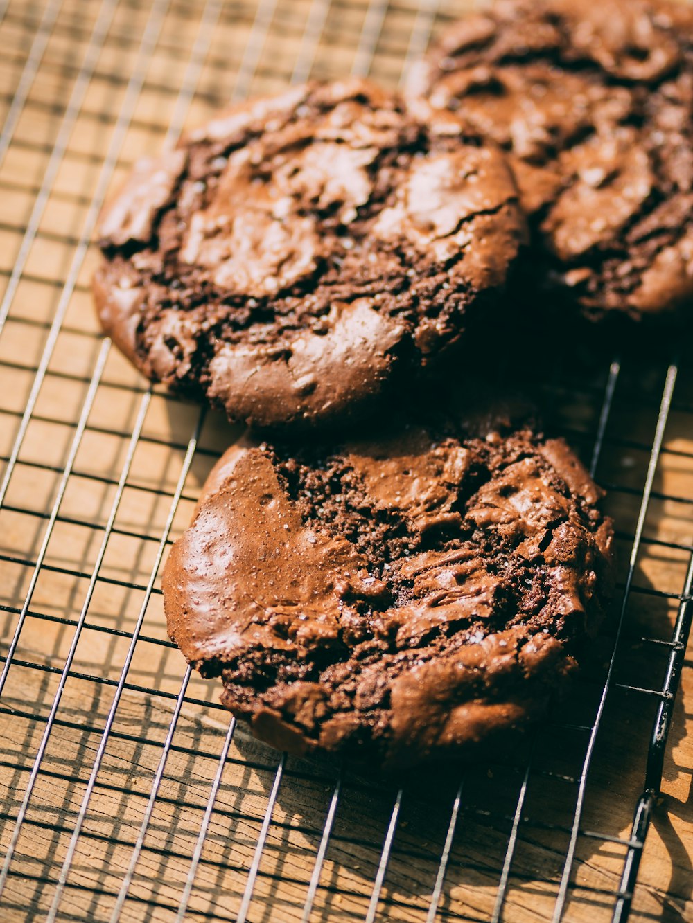 three chocolate cookies cooling on a cooling rack