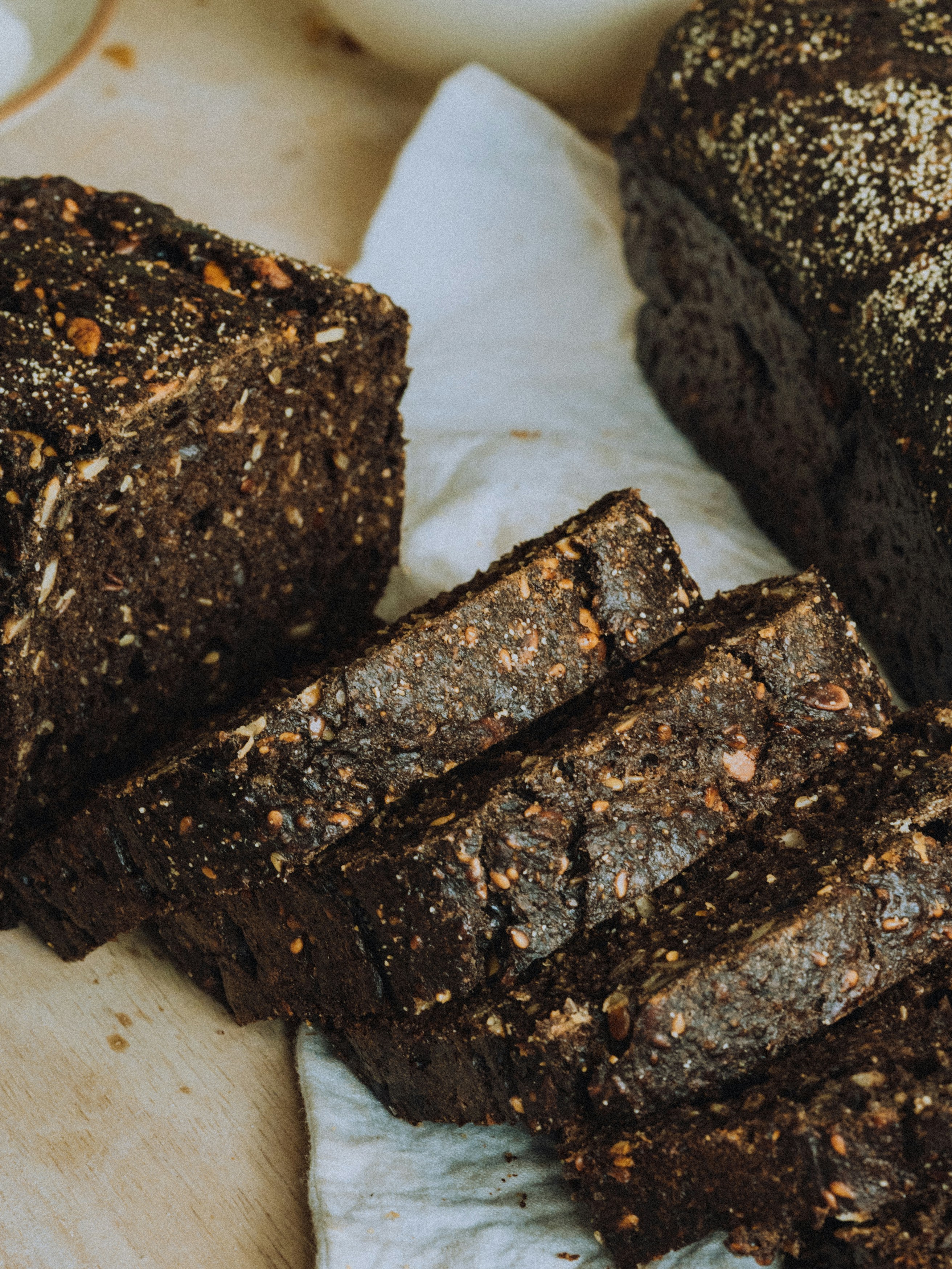 Dark rye bread loaf sliced on a linen cloth