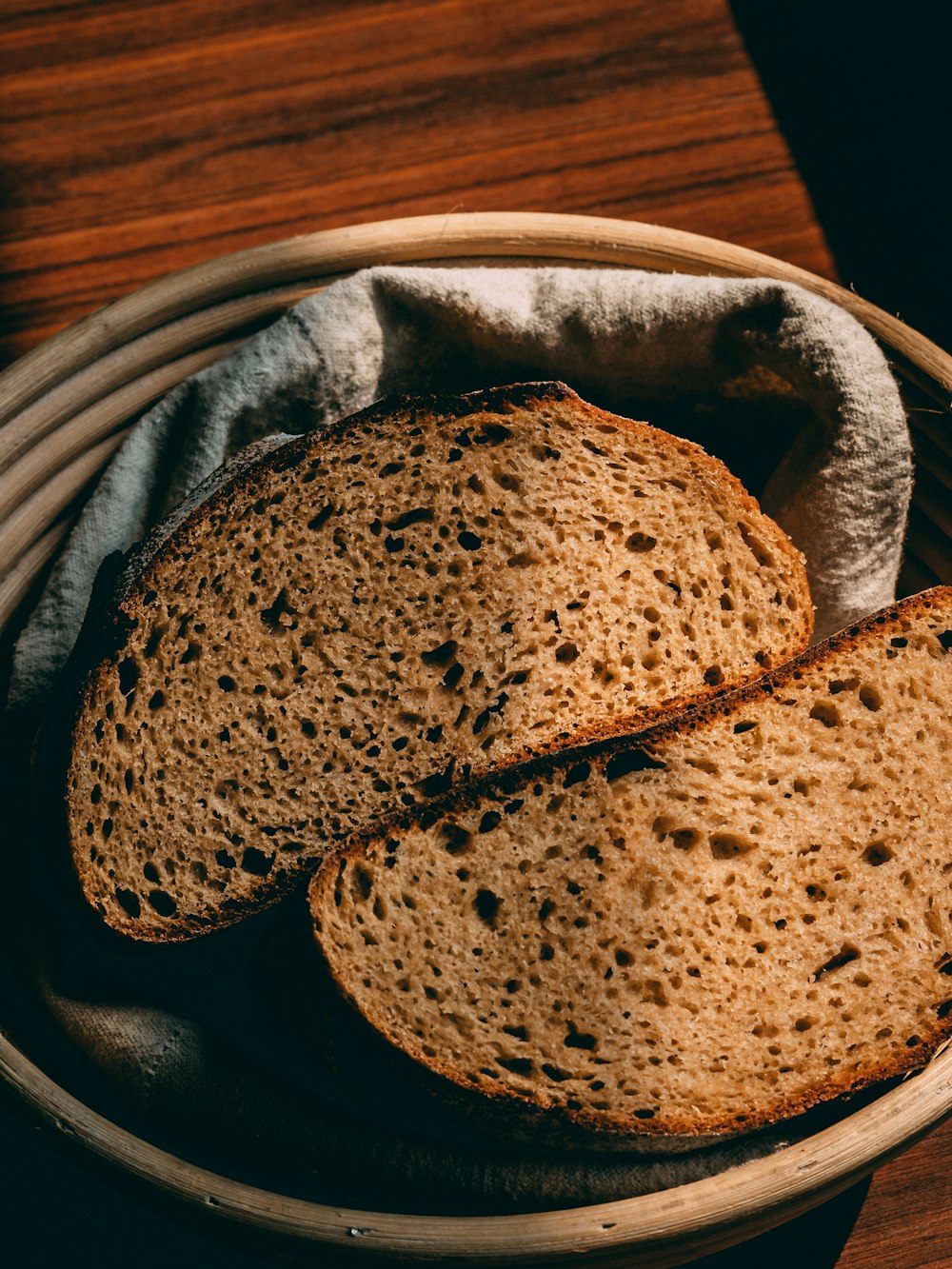 two loaves of bread in a basket on a table