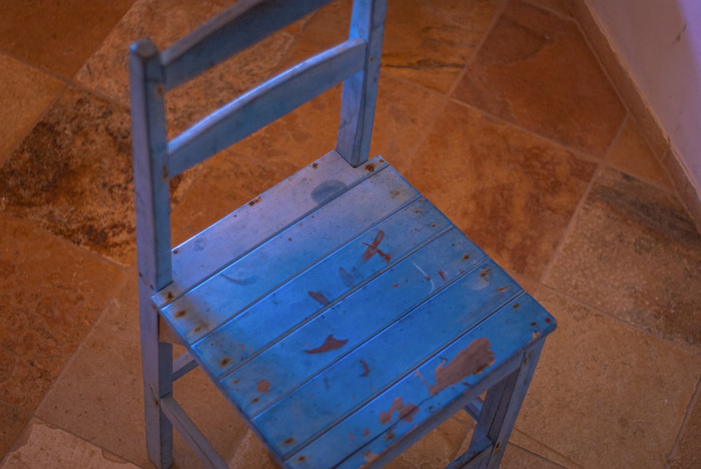 a blue chair sitting on top of a tiled floor