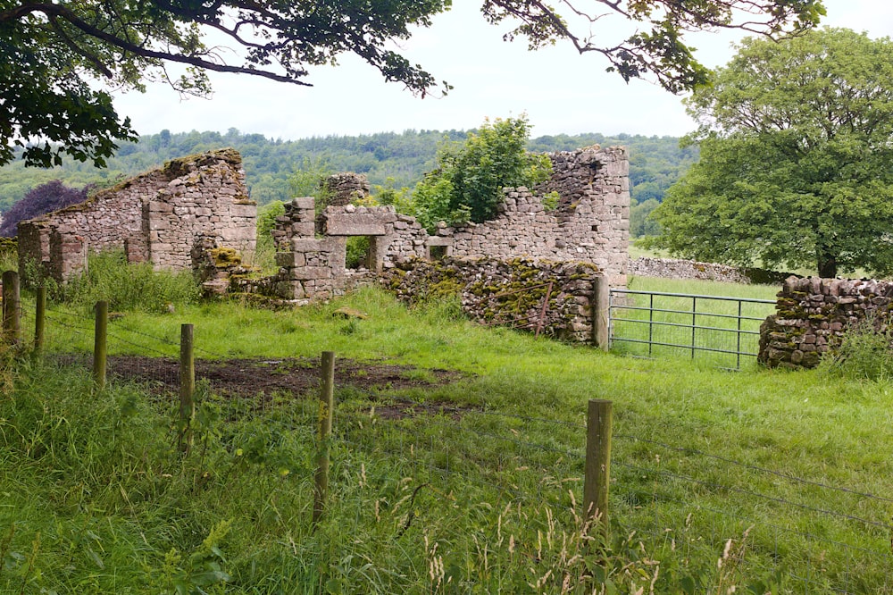 a stone building sitting on top of a lush green field