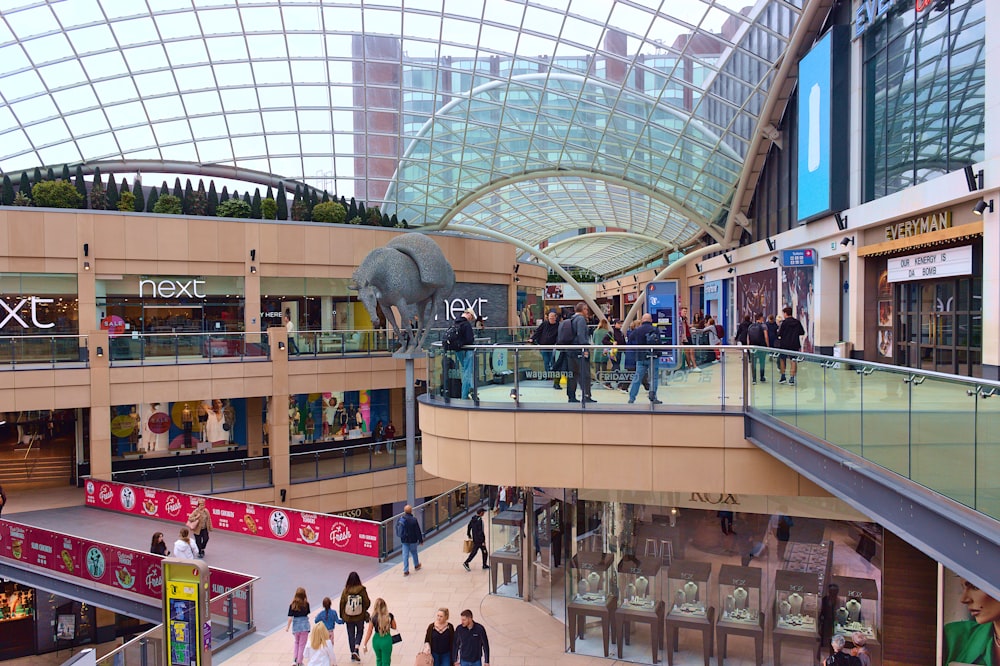 a group of people walking around a shopping mall