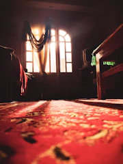 Sunlight filtering through linen curtains onto a handcrafted Bedouin-style seating area.