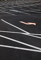 A wide-angle view of a freshly maintained parking lot with crisp white lines and clear directional arrows.