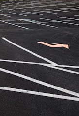 A freshly paved asphalt parking lot with clear striping at a commercial site.
