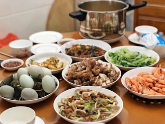 a wooden table topped with bowls of food