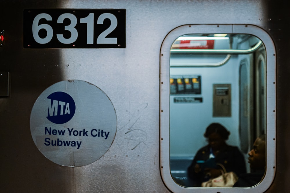 um vagão de metrô com um reflexo de um homem no espelho