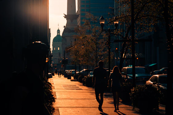 A warm, inviting neighborhood street scene at sunset with golden light reflecting on buildings.