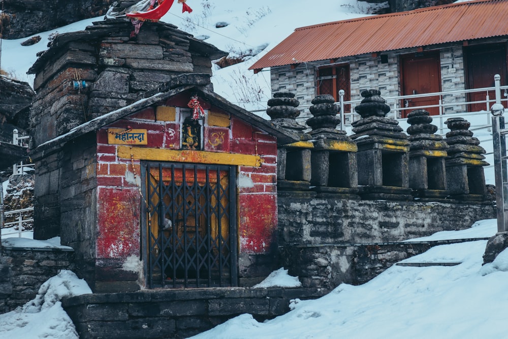 un bâtiment rouge et jaune reposant sur un sol enneigé