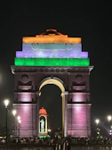 Golden hour view of India Gate with bustling crowds around.