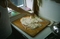 A chef carefully preparing fresh vermicelli bowls in the open kitchen.