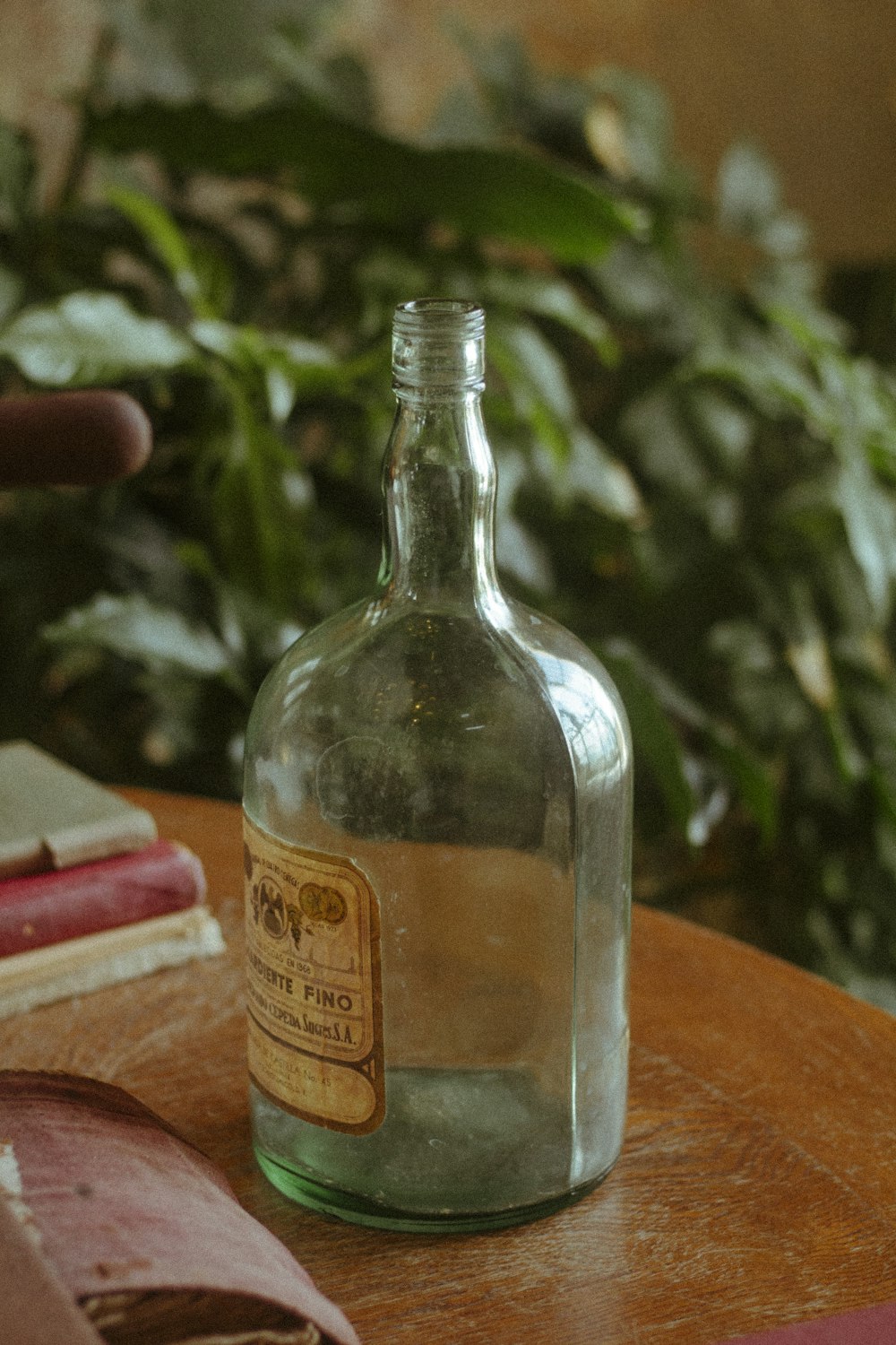 Una botella de vidrio encima de una mesa de madera