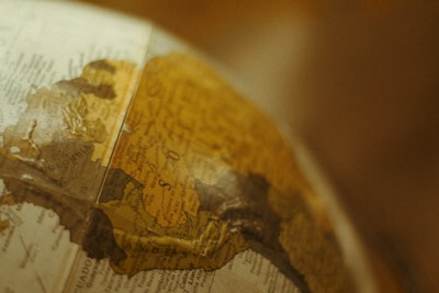 A close-up view of a vintage globe focusing on the South American continent, with countries like Colombia and surrounding areas partially visible. The map details are slightly faded, adding to the antique aesthetic.