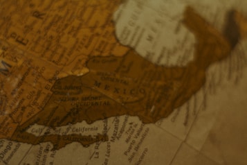 A close-up of a vintage-style globe showing parts of Mexico and the southwestern United States. The focus is on various city names and geographical features like the Sierra Madre Occidental. The overall look is warm and sepia-toned, suggesting an antiquated or nostalgic style.