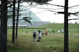 A group of diverse people walking in a lush green park.