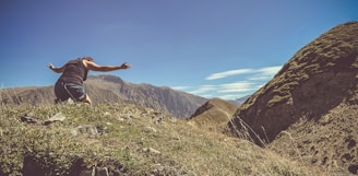 a man standing on top of a lush green hillside